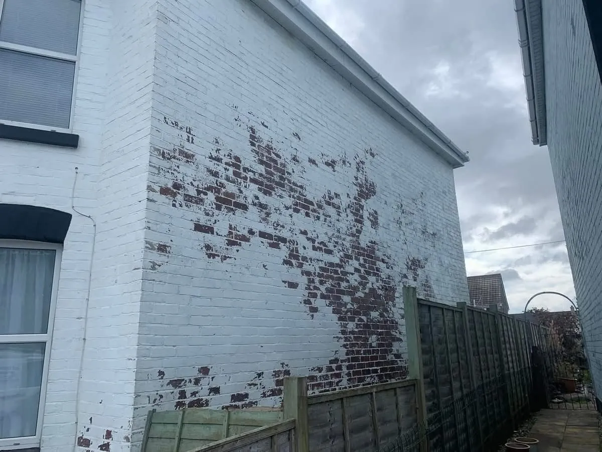 Peeling paint on a brick wall before redecoration in Polperro
